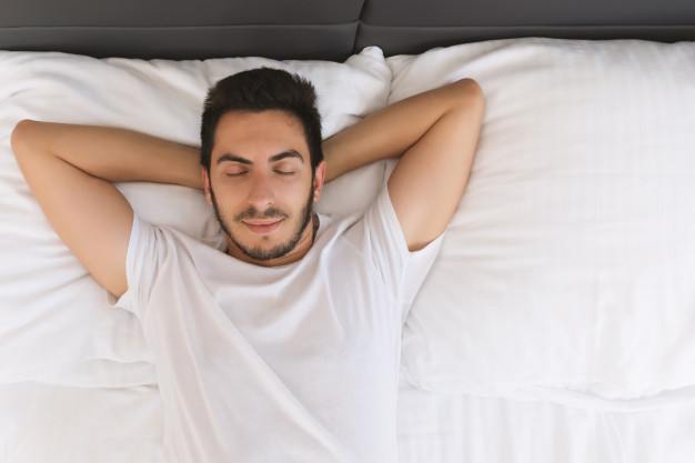 ¿Cuál es la mejor postura para dormir bien y descansar?: hombre duerme boca arriba - HeelEspaña